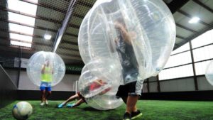 Treffen wird in der riesigen luftgefüllten Plastikblase nicht unbedingt einfacher: Das Verletzungsrisiko ist dafür beim Bubble Football sehr gering. Foto: Daniel Reinhardt (dpa)