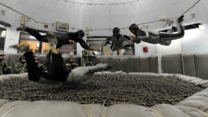 Hier ist eine Gruppe beim Indoor-Bodyflying zu sehen. Es werden Flugfiguren unter Anleitung eines Trainers ausprobiert.