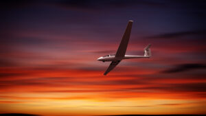 Die Hintergrundkulisse bildet ein Himmel, der herrlich durch das Abendrot eingefärbt ist. Davor zieht ein Segelflugzeug einsam seine Bahn. Man möchte mit dem Piloten tauschen.