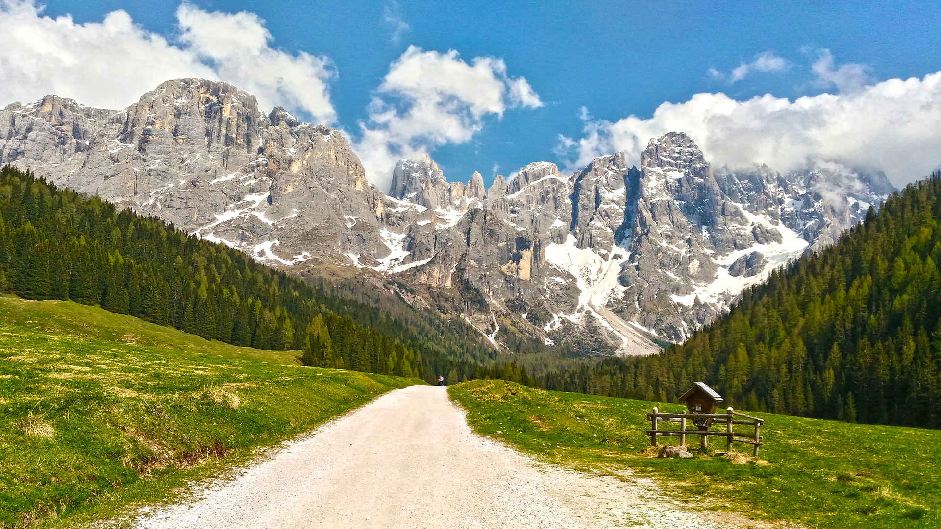 Fernwandern: Hoch gelegenes Tal in einem Naturpark in den Dolomiten mit zerklüfteten Gipfeln, sanften Wiesen, Weiden und Bächen.