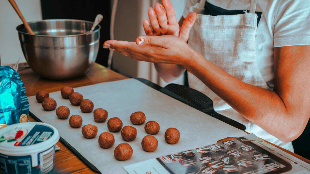 Bei der Herstellung von Pralinen ist viel Handarbeit gefordert. Hier werden ballförmige Pralinen geformt.
