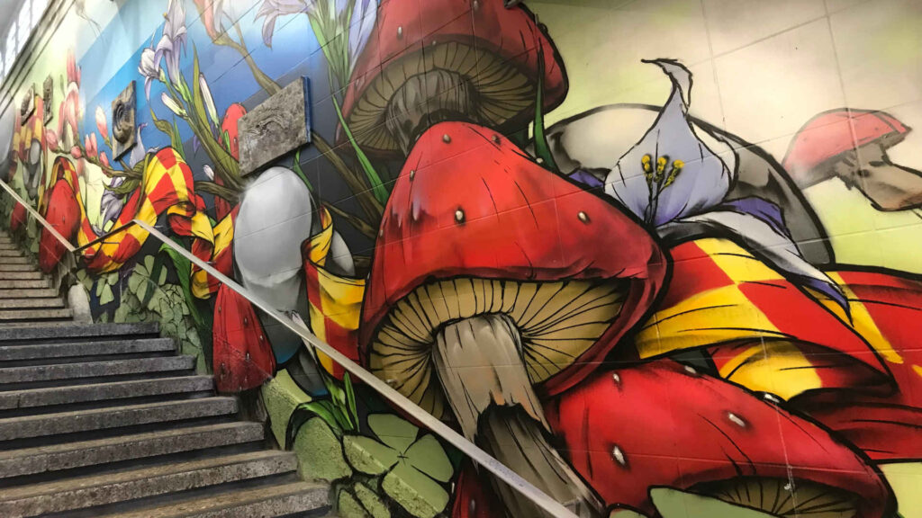 Graffiti – S-Bahn Haltestelle Stuttgart Nordbahnhof. Die Treppe wurde von Christoph Ganter mit einem Graffiti verziert. Es dominieren Pilze, Blumen und ein karierter Schal.