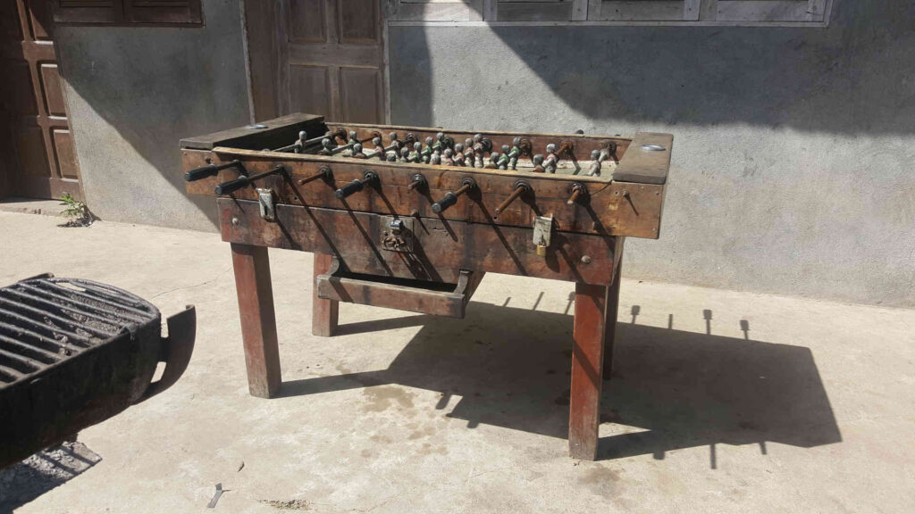 Tischfußball – Ein Original-Kicker mit Münzeinwurf und Metalleinsätzen für Getränke oder Aschenbecher. Hergestellt aus Massivholz Mitte des 20. Jahrhunderts.