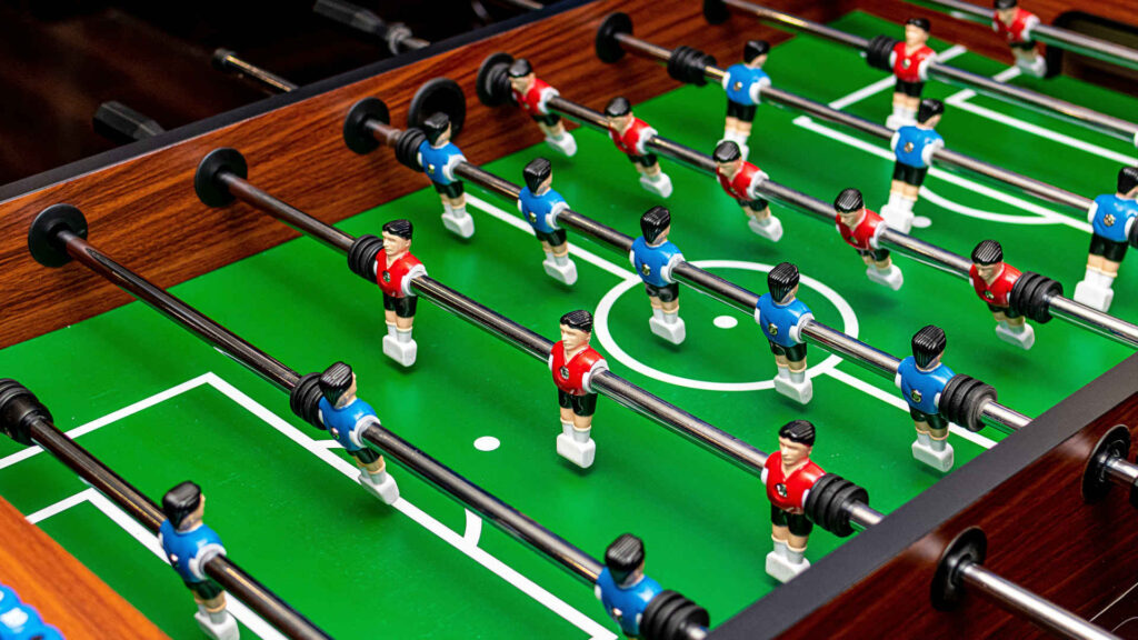 Tischfußball – Hier ein Typischer Tischkicker mit grünem Spielfeld.