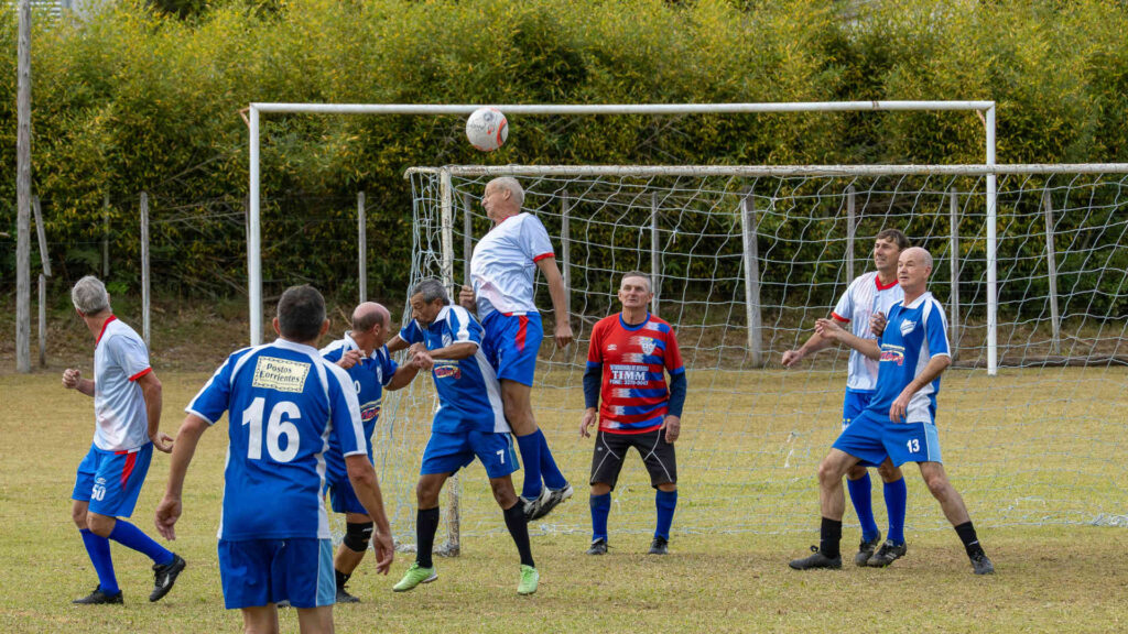 Fußball – Alle Altersklassen können Fußball spielen. Hier köpft ein älterer Herr den Ball.