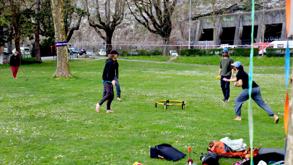 Roundnet – Vier junge Menschen spielen konzentriert Roundnet in einem Park.