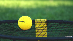 Roundnet wird auch Spikeball genannt. Hier ein gelber Ball mit dem Aufdruck der Firma „Spikeball“.